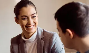 Community Worker with Psychology Degree Smiling with Male Client