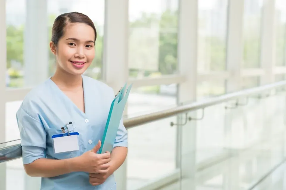 Smiling Medical Assistant Reviewing Patient Chart