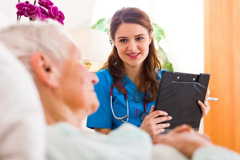 Smiling Medical Assistant with Clipboard Speaking with Geriatric Patient